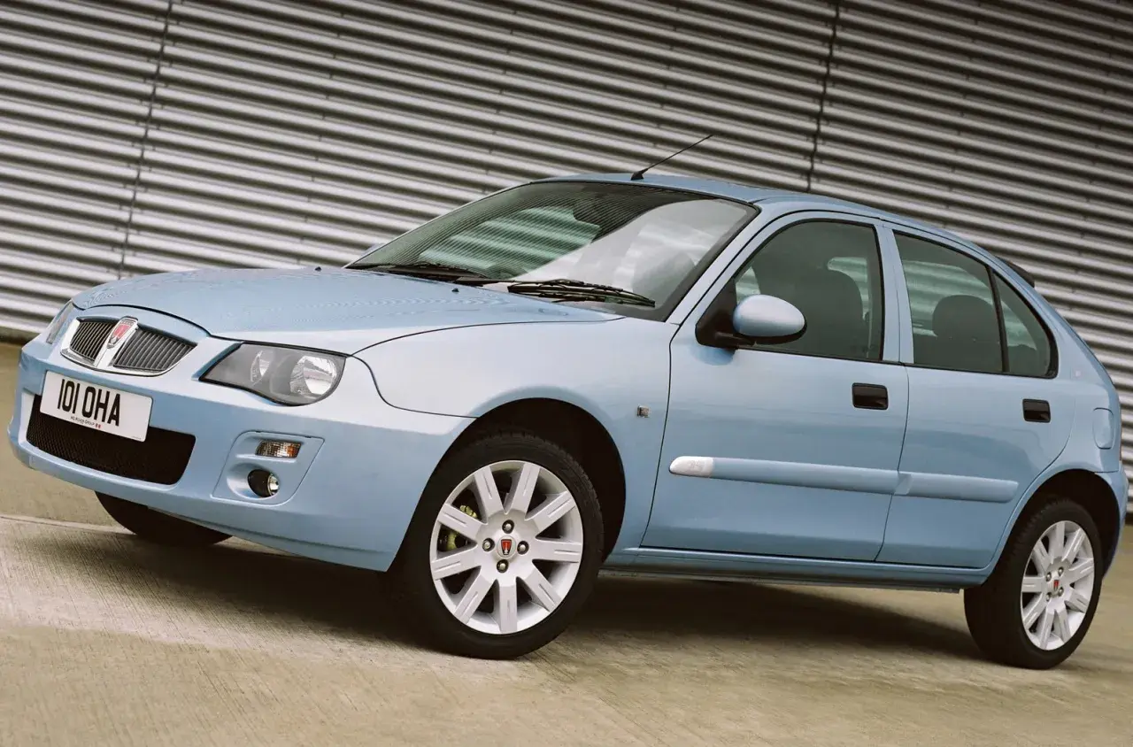 Hellblauer Rover 25 Gebrauchtwagen steht vor einer geriffelten Wand.