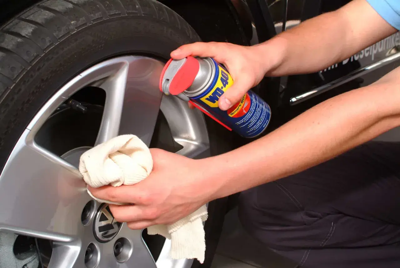 Person reinigt Felgen mit WD-40 und Tuch. Ein Hausmittel, das oft für felgen reinigen hausmittel verwendet wird.