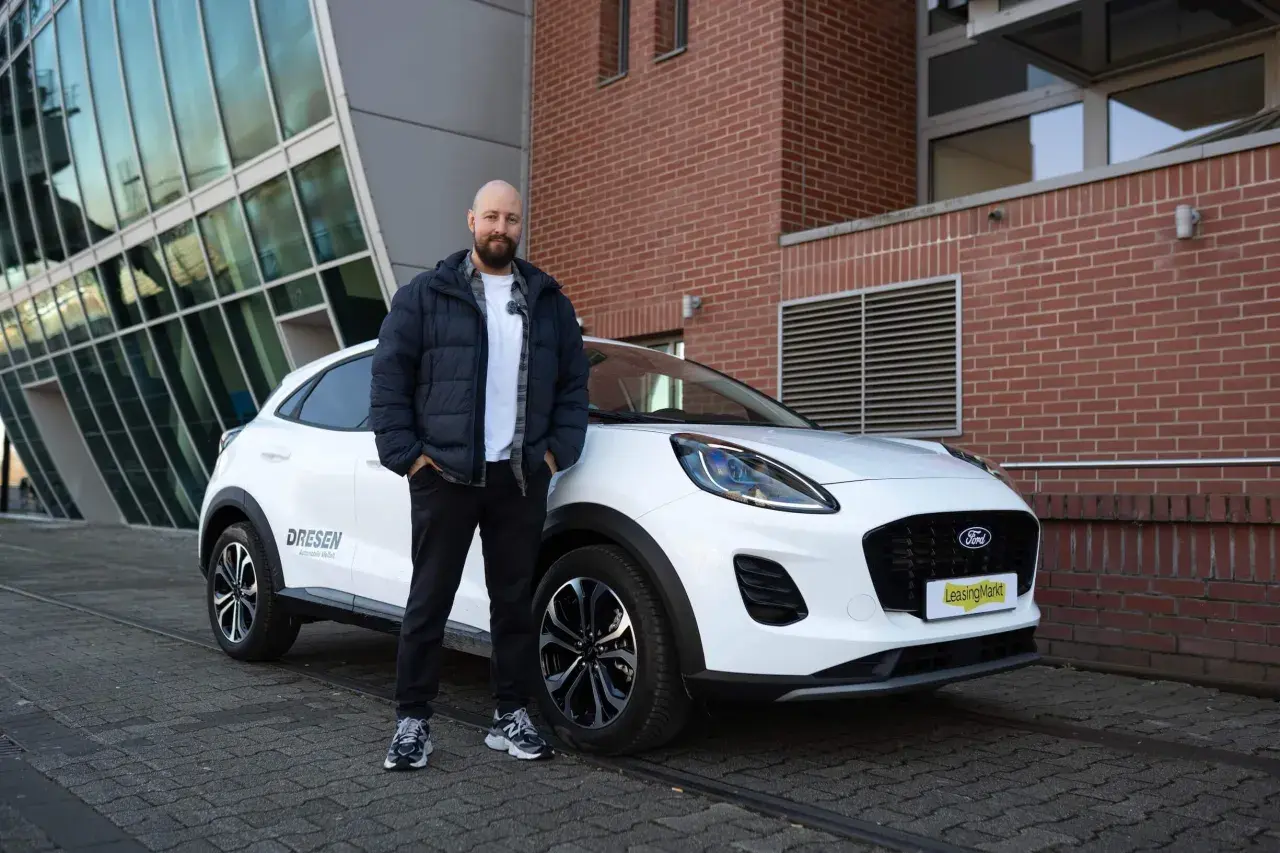 Mann steht neben weißem Ford Puma für einen Test.