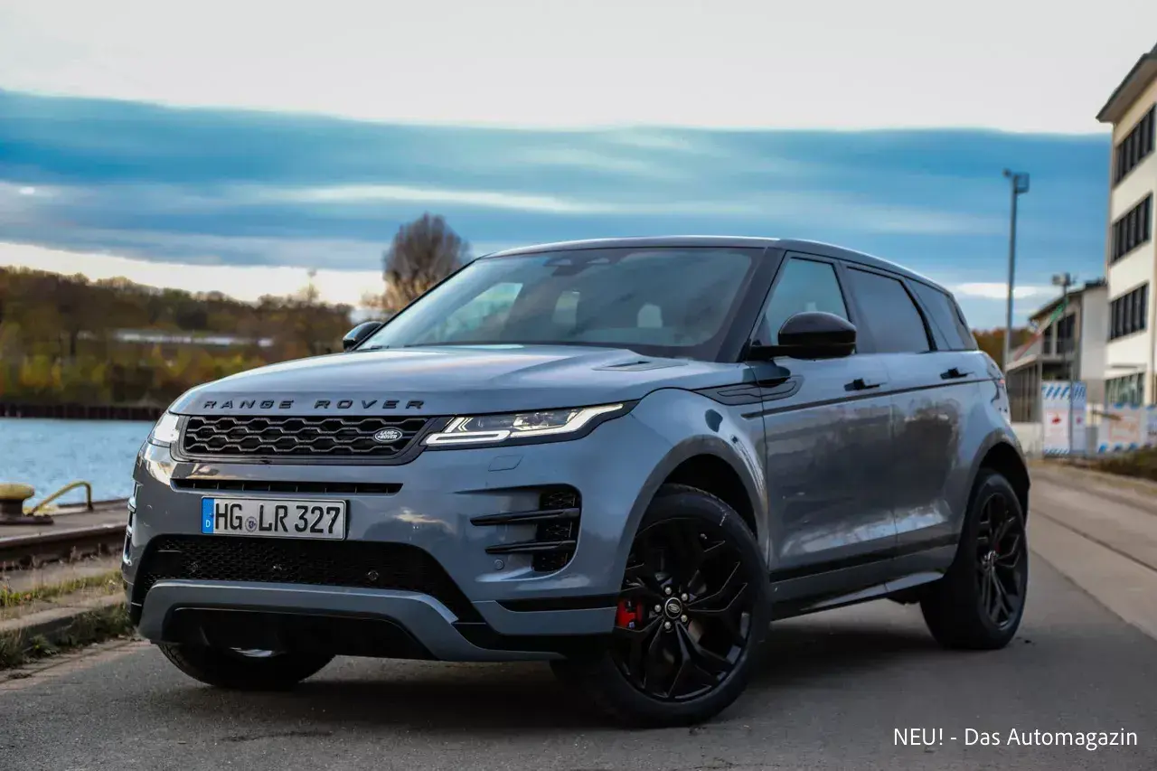Grauer Range Rover Evoque, dessen Länge durch die dynamische Seitenansicht betont wird. Ein stilvolles SUV am Wasser.