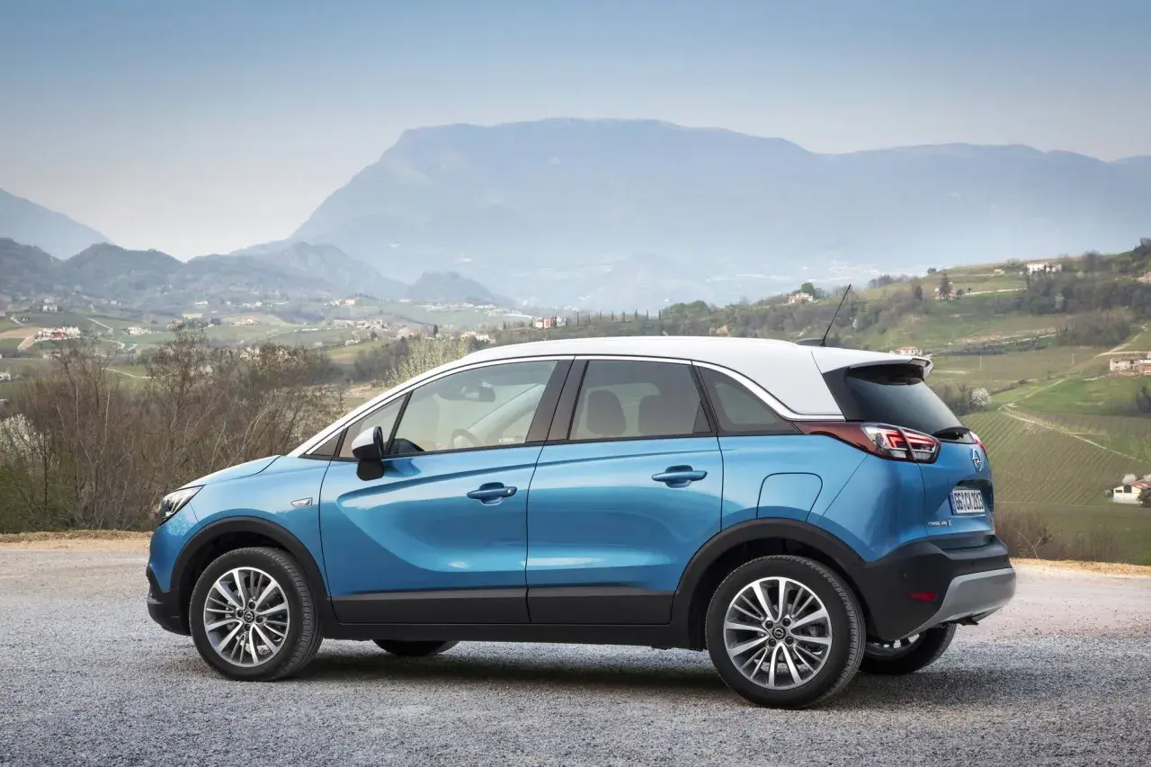 Blauer Opel Crossland parkt in malerischer Berglandschaft. Keine Probleme mit diesem Auto, nur Fahrspaß!