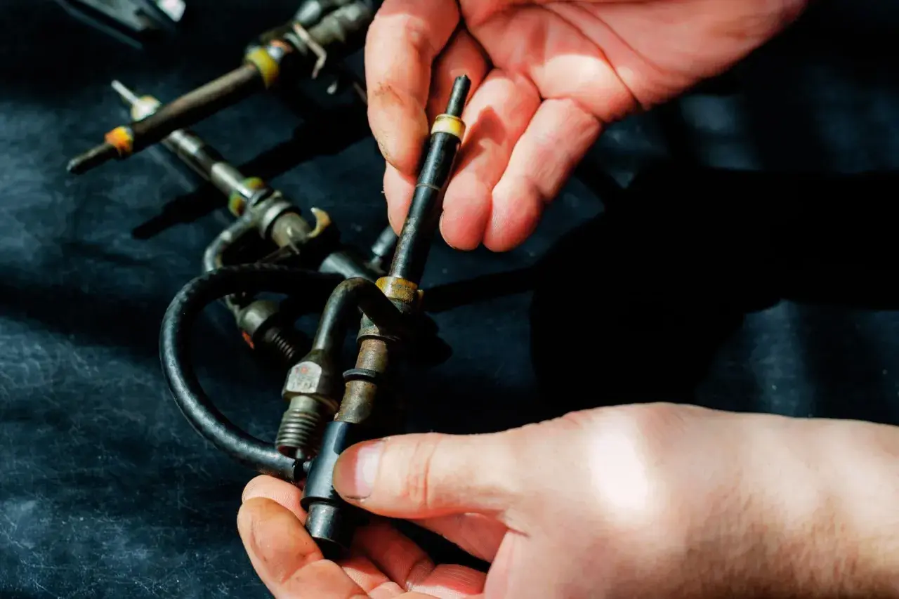 Hände halten Diesel-Einspritzdüsen. Ein Grund, warum der Motor ruckelt im Stand, könnte eine defekte Düse sein.