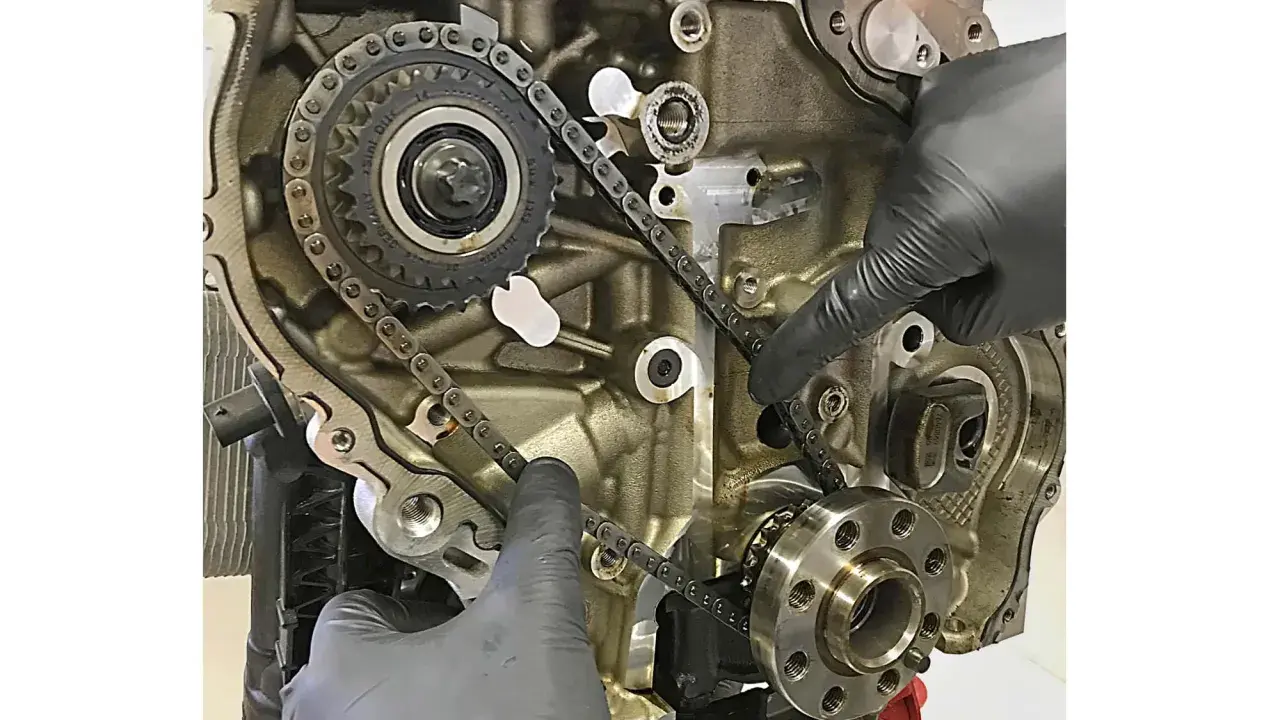 Hände prüfen die Steuerkette eines Motors. Die Frage, wie lange hält eine steuerkette, hängt von Wartung und Material ab.