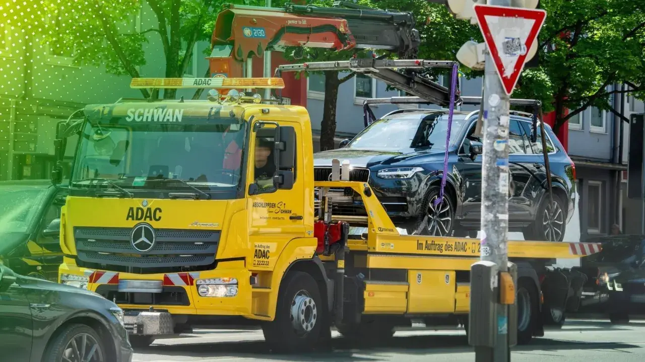 Gelber ADAC-Abschleppwagen mit SUV auf Ladefläche. Informiert über die Kosten eines Abschleppdienstes.