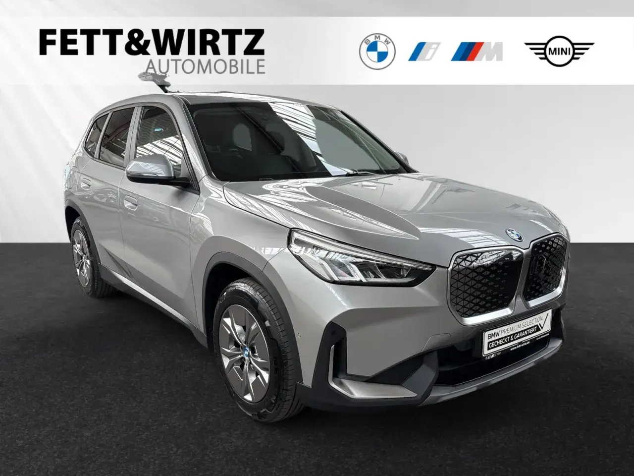 Silberner BMW iX1, ein Vorbote der neuen Klasse, steht bereit.