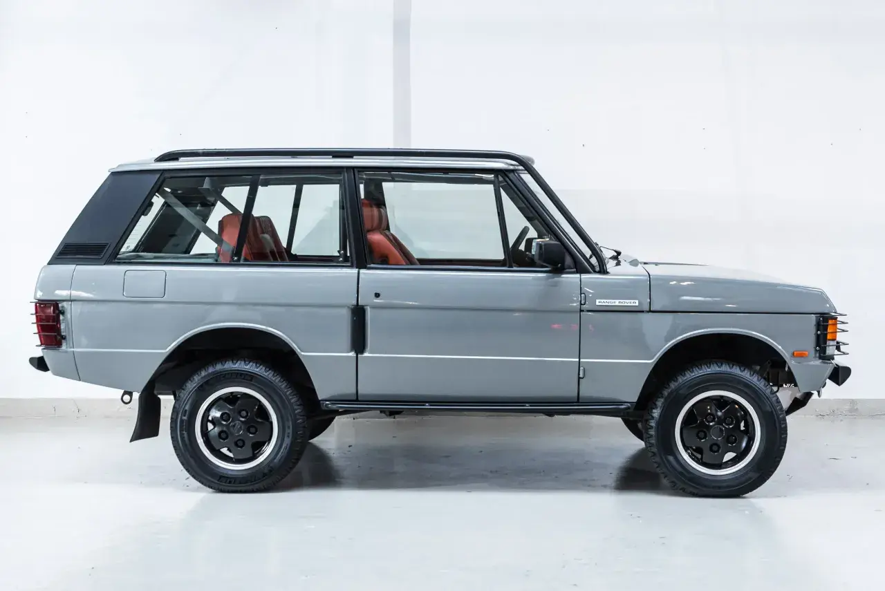 Grauer Range Rover 3-Türer mit roten Ledersitzen, bereit für jedes Abenteuer.