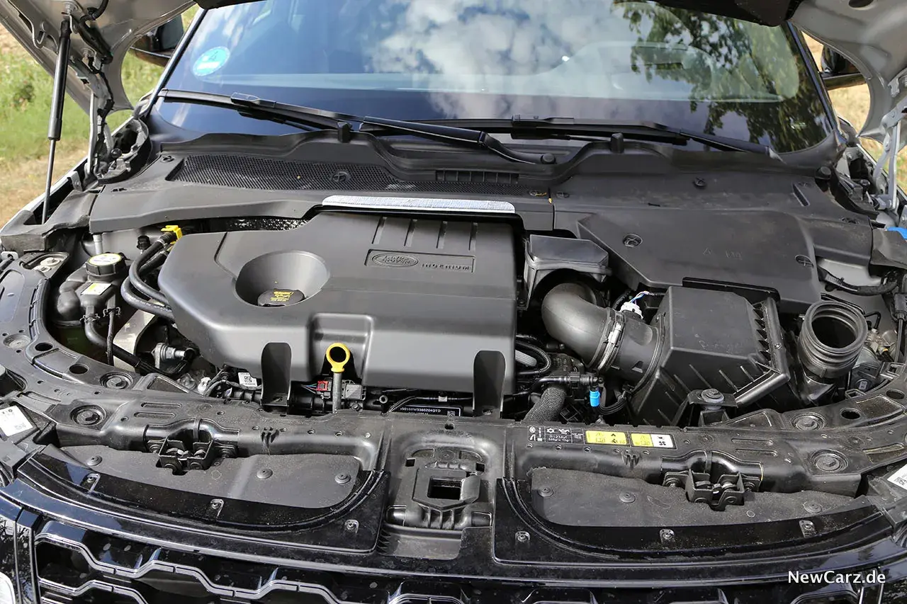 Motorraum eines Range Rover Evoque. Der Motor ist abgedeckt, aber die Leistung des Fahrzeugs, die durch die PS angegeben wird, ist spürbar.