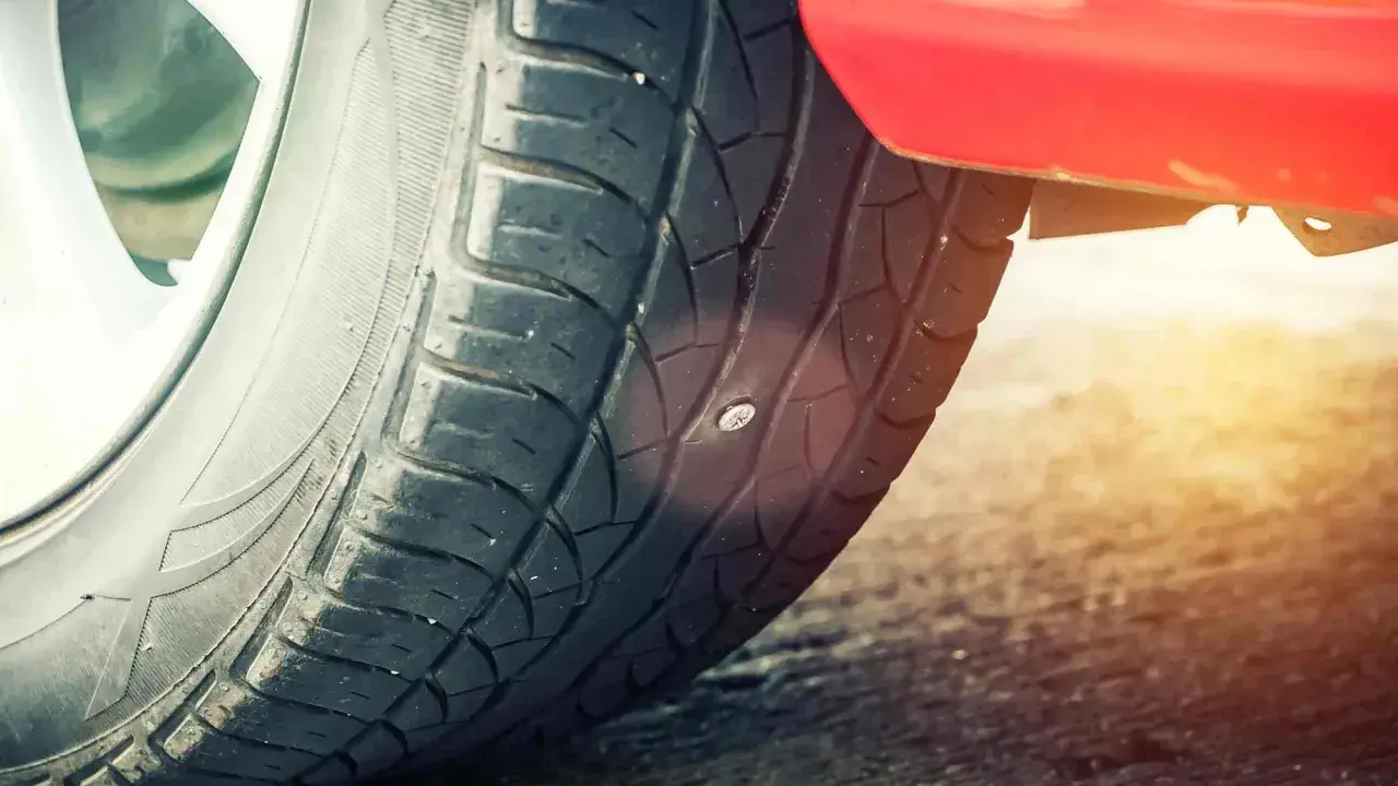 Ein Nagel steckt im Autoreifen. Zeit für einen auto reifen flicken, bevor die Luft entweicht.