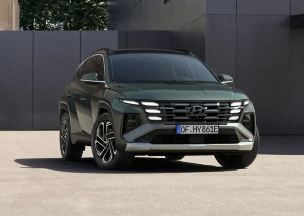 Ein grüner Hyundai Tucson, bereit für 2026, steht vor einer modernen Fassade.