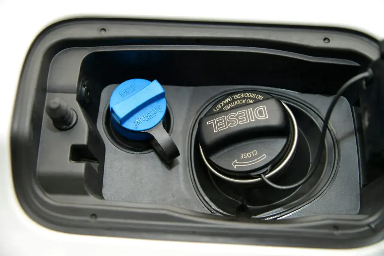Tankklappe mit blauem AdBlue-Deckel und schwarzem Diesel-Deckel. Der Diesel-Stand ist niedrig.