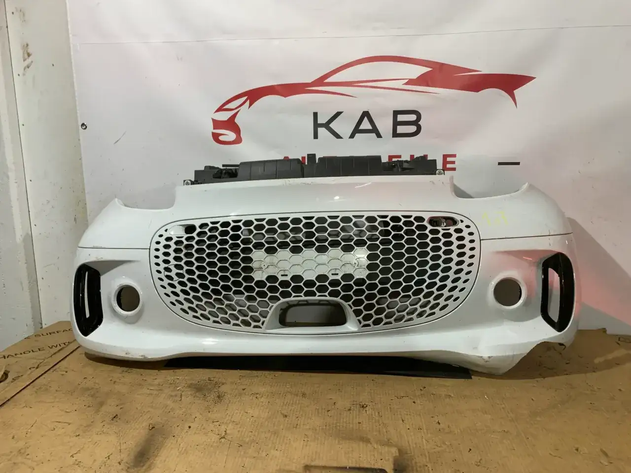 Wei&szlig;e Sto&szlig;stange mit Wabenmuster-Grill, bereit f&uuml;r ein Facelift-Auto.