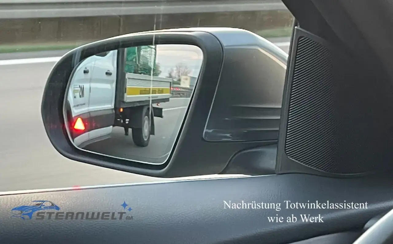 Ein LKW im Rückspiegel, mit rotem Dreieck als Warnung. Nachrüstung Totwinkelassistent wie ab Werk.
