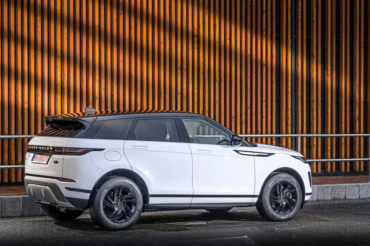 Wei&szlig;er Range Rover Evoque 2.0 Diesel, moderne Optik vor Holzfassade. Gute Erfahrungen mit diesem Modell sind zu erwarten.