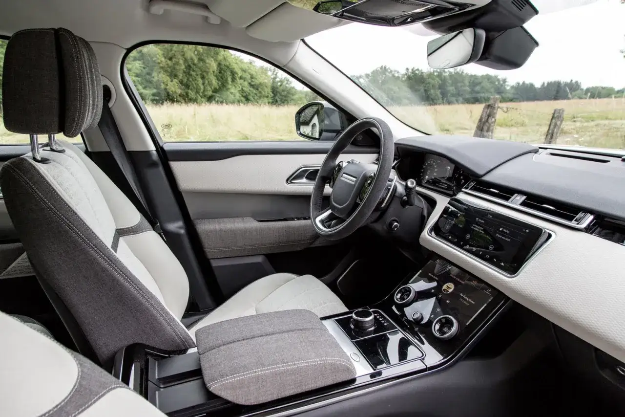 Innenraum eines Range Rover Velar mit zweifarbigen Sitzen und modernem Infotainmentsystem. Informieren Sie sich über die Land Rover InControl Kosten für diese Technologie.
