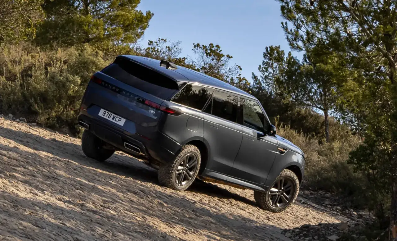 Dunkelgrauer Range Rover fährt bergauf auf unbefestigtem Weg. Ideal, wenn Sie einen Land Rover kaufen möchten, der jedes Gelände meistert.