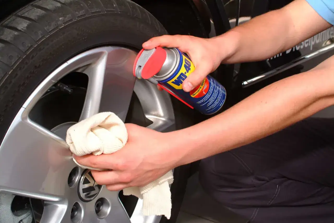 H&auml;nde reinigen Felgen mit WD-40 und Tuch. Ein einfaches Hausmittel f&uuml;r gl&auml;nzende Felgen.