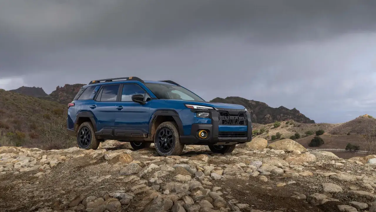 Blauer Subaru Outback 2026 auf felsigem Untergrund, bereit f&uuml;r jedes Abenteuer in bergiger Landschaft.