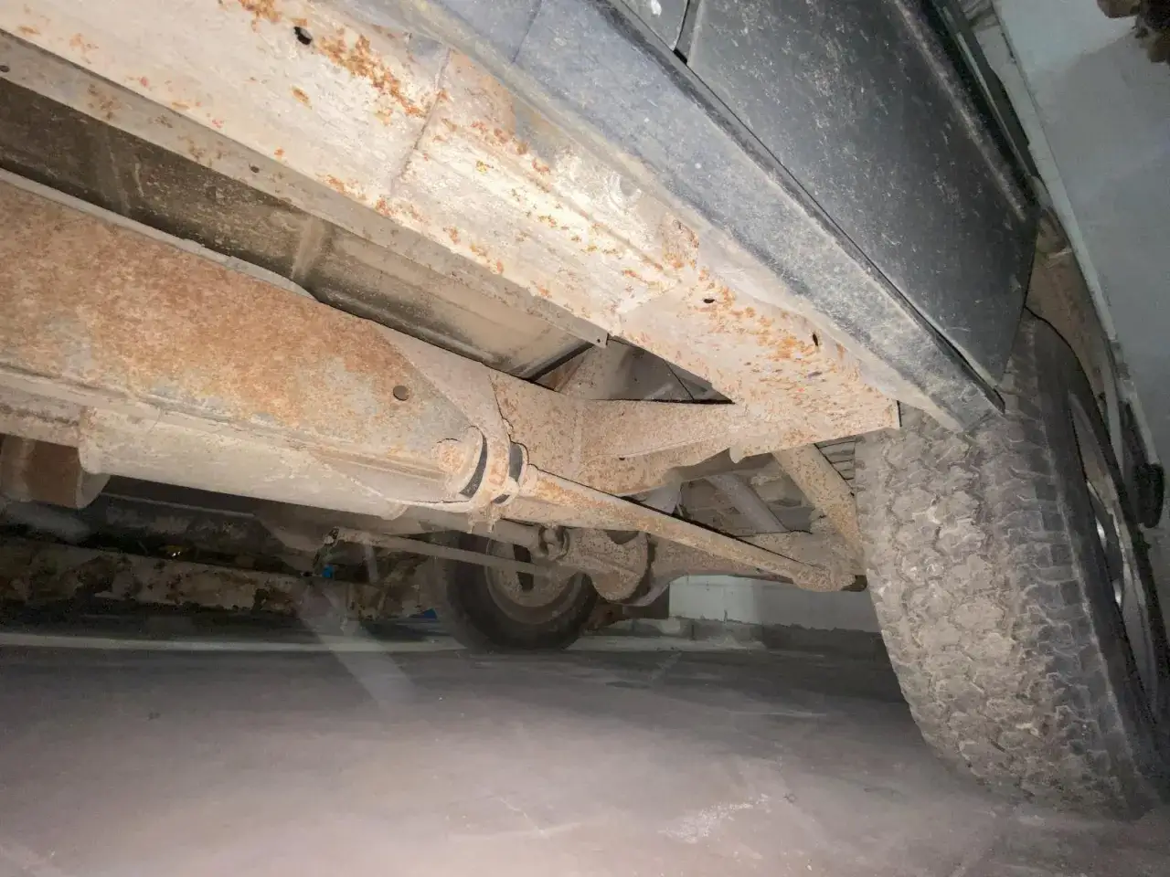 Rostiger Unterboden eines Rover Gebrauchtwagens. Deutliche Spuren von Korrosion an Rahmen und Achsen.