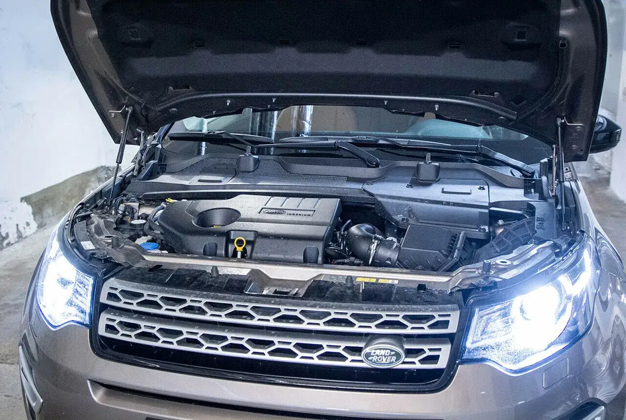 Motorraum eines Land Rover Discovery Sport 2.0 TD4. Offene Motorhaube zeigt den Motor, der auf mögliche Probleme untersucht wird.