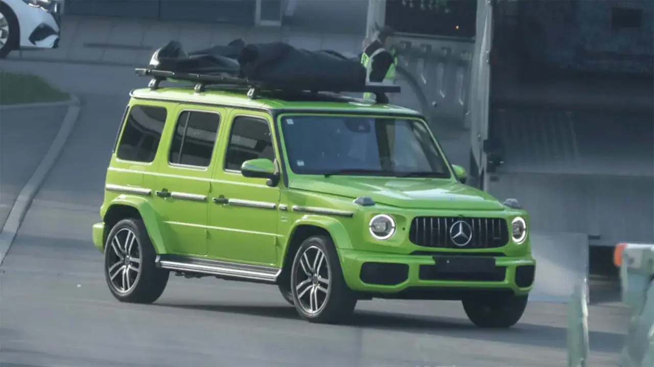 Leuchtend gr&uuml;ner Mini G-Klasse Mercedes mit Gep&auml;ck auf dem Dach, bereit f&uuml;r ein Abenteuer.