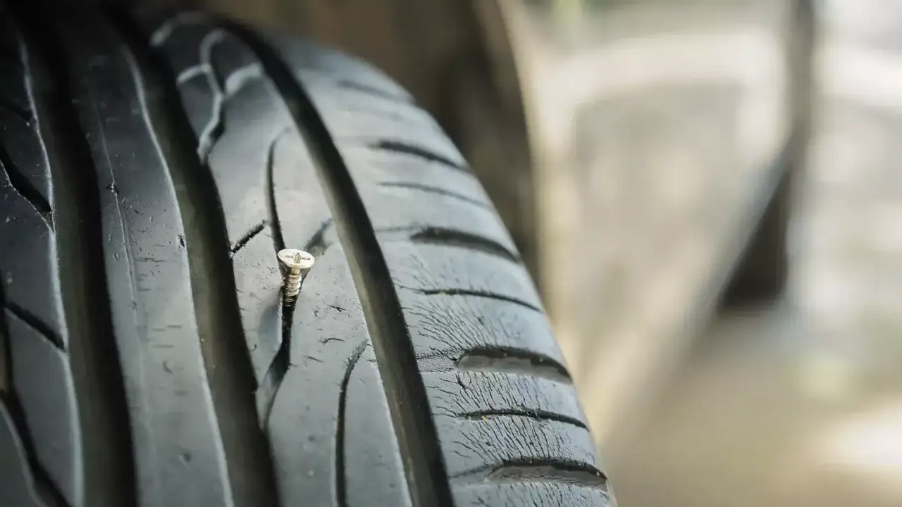 Schraube im Autoreifen: Ein kleiner Schaden, der zeigt, dass Autoreifen flicken erlaubt ist, um die Fahrt fortzusetzen.
