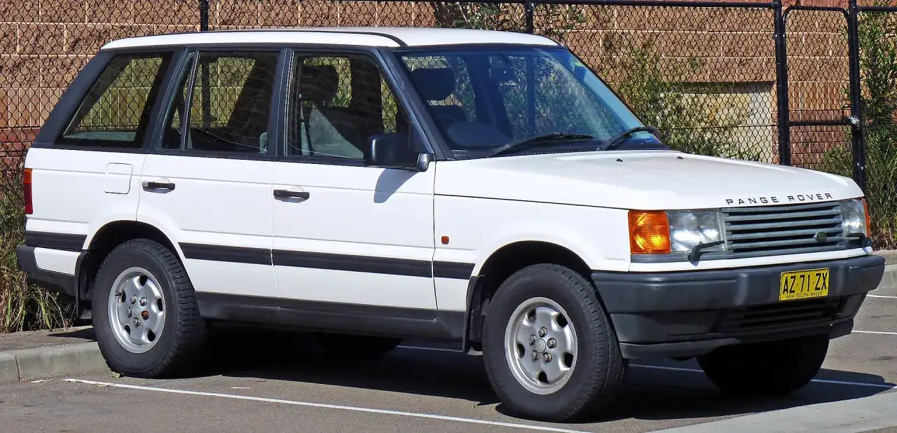 Wei&szlig;er Range Rover gebraucht Automatik, geparkt vor einem Zaun.