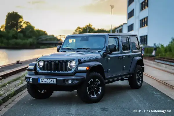 Grauer Jeep Wrangler Rubicon am Wasser, bereit für Abenteuer. Trotz seiner Robustheit gibt es auch Jeep Wrangler Schwachstellen zu beachten.