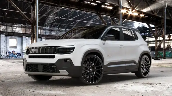 Weißer Jeep mit auffälligen schwarzen Alufelgen 22 Zoll in einer alten Fabrikhalle.