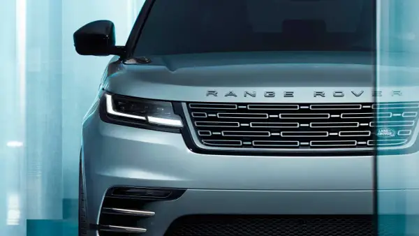 Der Kühlergrill eines silbernen Range Rover mit dem Schriftzug "RANGE ROVER" und dem Land Rover Logo. Ein Fahrzeug, das "land rover approved" ist.