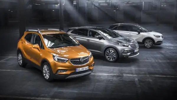 Drei Opel-Modelle in einem Parkhaus: ein orangefarbener Mokka, ein grauer Grandland X und ein weißer Crossland X. Ein Ausblick auf die Opel Modelle 2026.