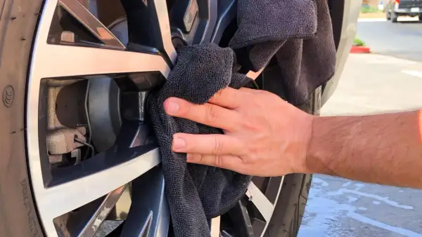 Hand poliert Felge mit schwarzem Tuch. Ein einfacher felgenreiniger hausmittel-Trick für glänzende Räder.