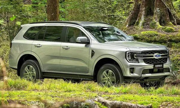 Silberner Ford Everest fährt durch grünen Wald in Deutschland.